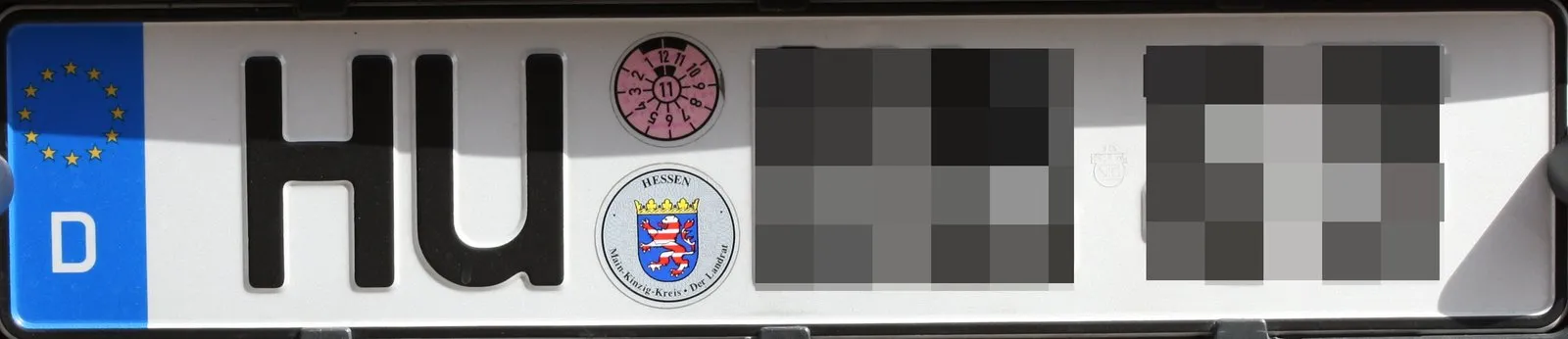 Matrícula de automóvel com o selo redondo da inspeção técnica periódica